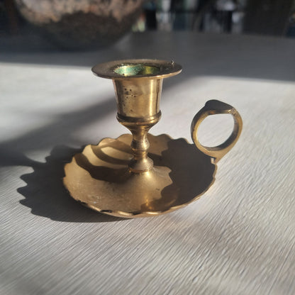 Vintage brass chamberstick with scalloped drip tray and finger handle.