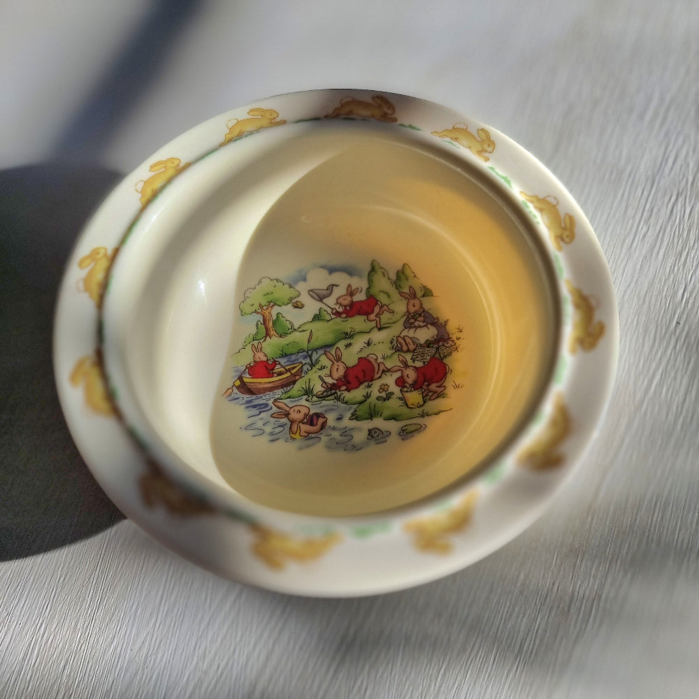 Royal Doulton Bunnykins melamine bowl with rabbit scenes in centre and hopping bunny border around rim.
