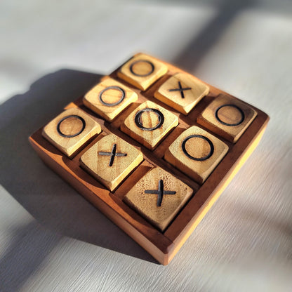 Handmade wooden tic tac toe board with removable X and O wooden playing pieces.