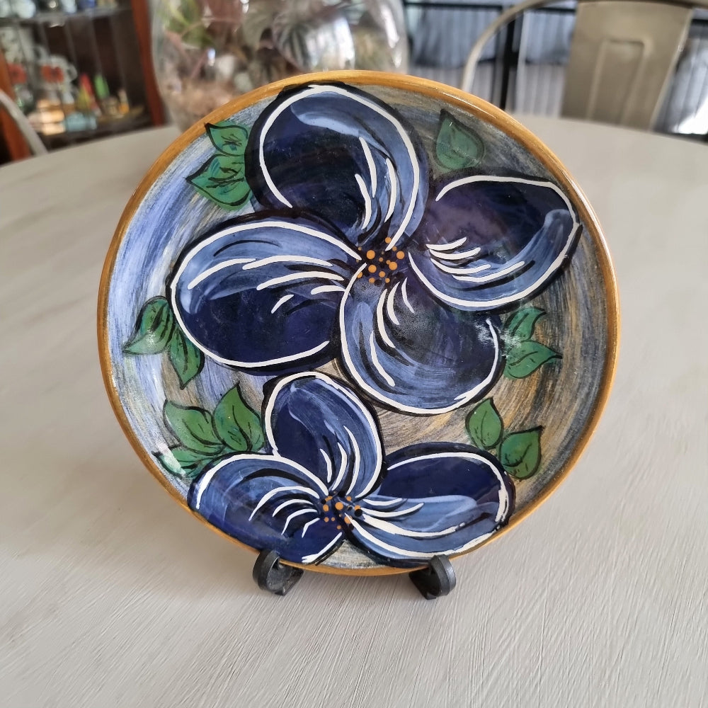 Hand painted ceramic plate with large blue flowers and green leaves signed Bev NZ 1998