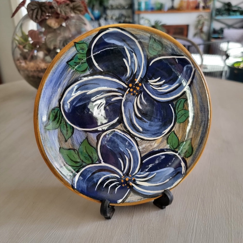 Hand painted ceramic plate with large blue flowers and green leaves signed Bev NZ 1998