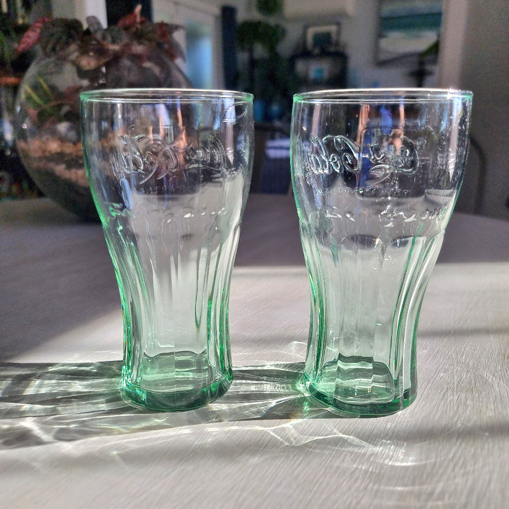 Two green-tinted Coca-Cola Beijing Olympics drinking glasses with embossed Coke logo.