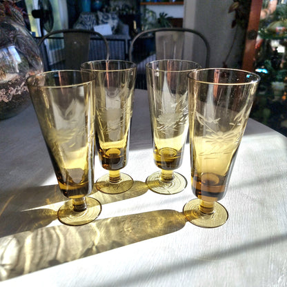 Set of four amber champagne flutes with etched floral pattern and short stems