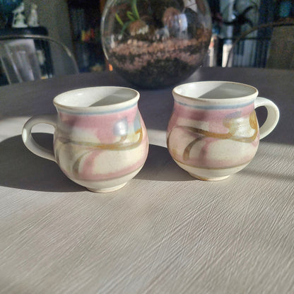 Pair of Michael Macmillan stoneware cups with blush pink, cream and gold swirl glaze