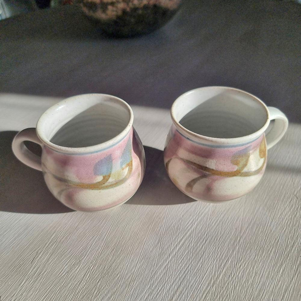 Pair of Michael Macmillan stoneware cups with blush pink, cream and gold swirl glaze