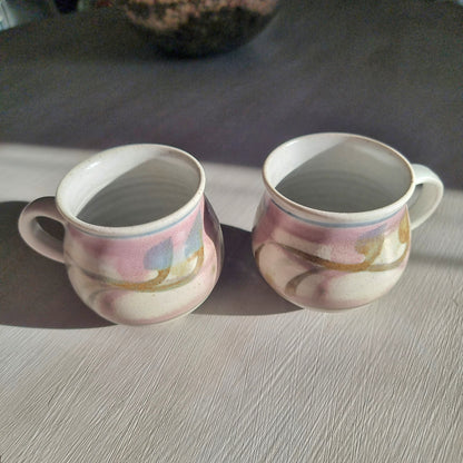 Pair of Michael Macmillan stoneware cups with blush pink, cream and gold swirl glaze