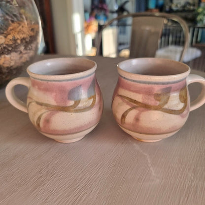 Pair of Michael Macmillan stoneware cups with blush pink, cream and gold swirl glaze