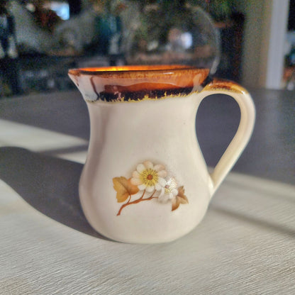 Kermiko pottery cream jug with cream body, rich brown drip glaze rim
