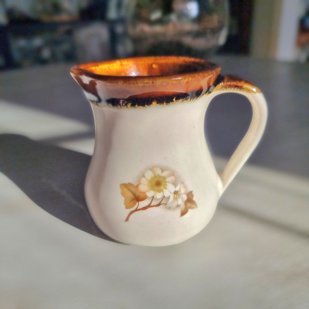 Kermiko pottery cream jug with cream body, rich brown drip glaze rim