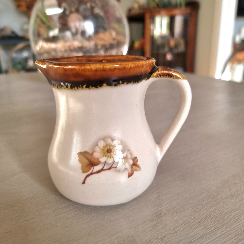 Kermiko pottery cream jug with cream body, rich brown drip glaze rim