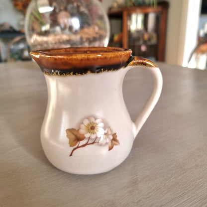 Kermiko pottery cream jug with cream body, rich brown drip glaze rim