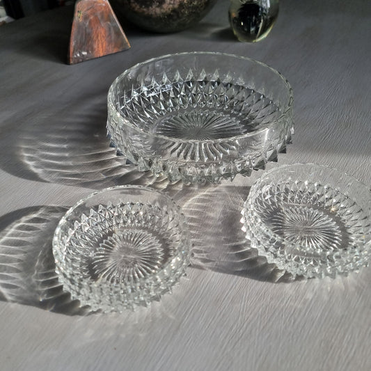 Pressed glass diamond point bowl set with one large and two small bowls, sparkling in natural light