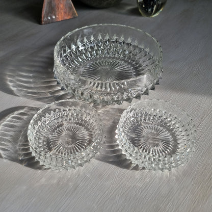Pressed glass diamond point bowl set with one large and two small bowls, sparkling in natural light