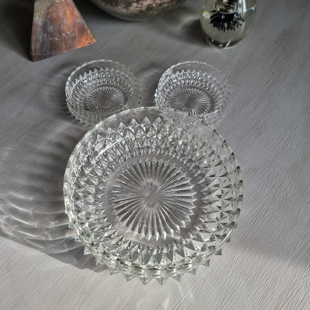 Pressed glass diamond point bowl set with one large and two small bowls, sparkling in natural light