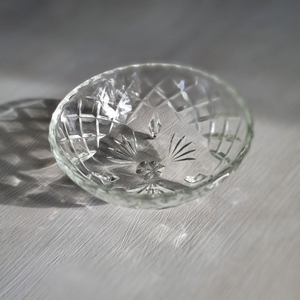 Cut glass trinket bowl with starburst and diamond pattern on three small feet