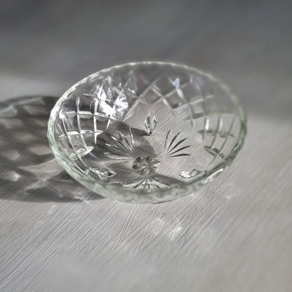 Cut glass trinket bowl with starburst and diamond pattern on three small feet