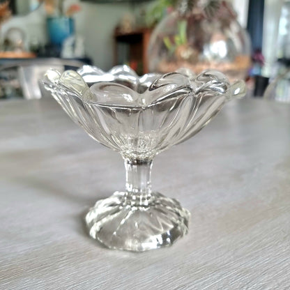Vintage pressed glass footed dish with scalloped petal rim and ribbed bowl panels