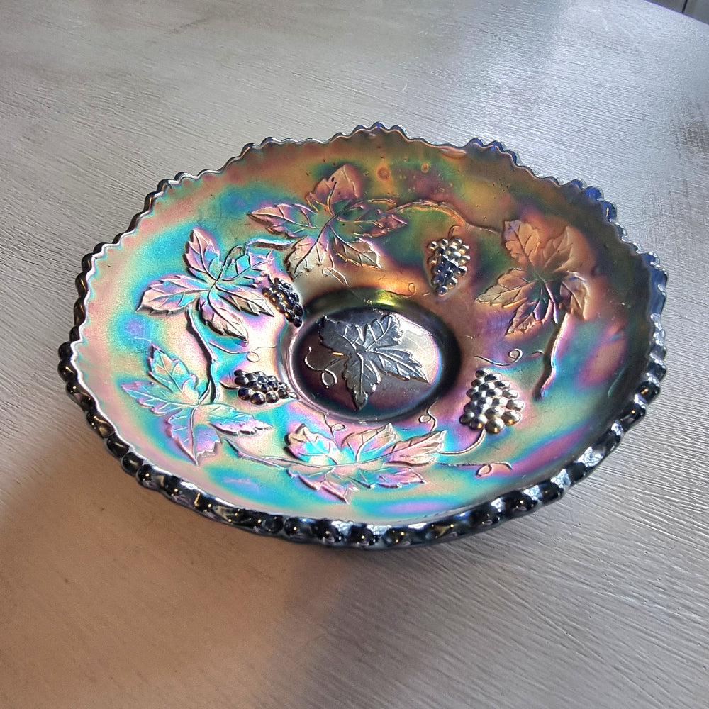 Vintage Fenton carnival glass berry bowl with iridescent rainbow finish and raised grapevine pattern.