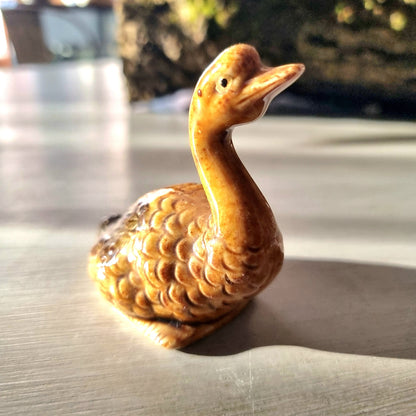 Vintage glazed ceramic goose figurine with honey and amber feather texture