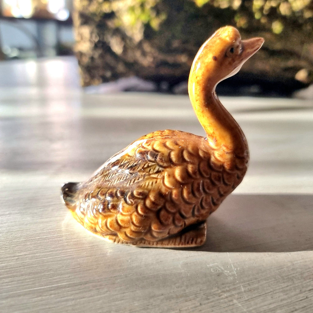 Vintage glazed ceramic goose figurine with honey and amber feather texture