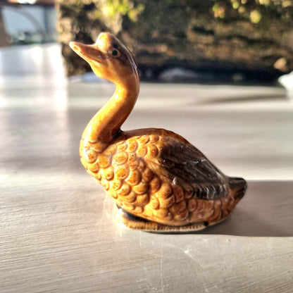 Vintage glazed ceramic goose figurine with honey and amber feather texture