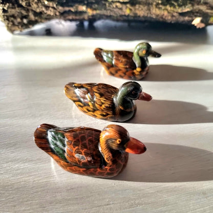 Trio of vintage hand-painted ceramic duck figurines with lustre glaze finish