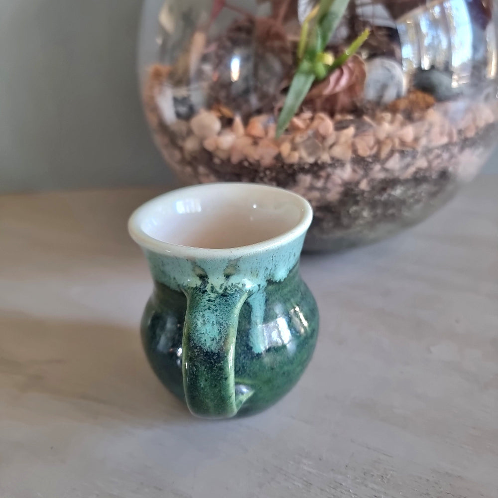 Vintage green studio pottery mug with cream rim and handle