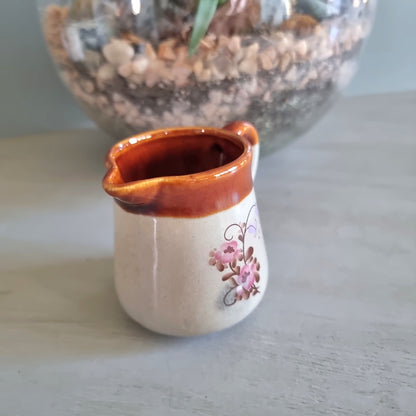 Vintage cream jug with brown glazed rim and pink floral design