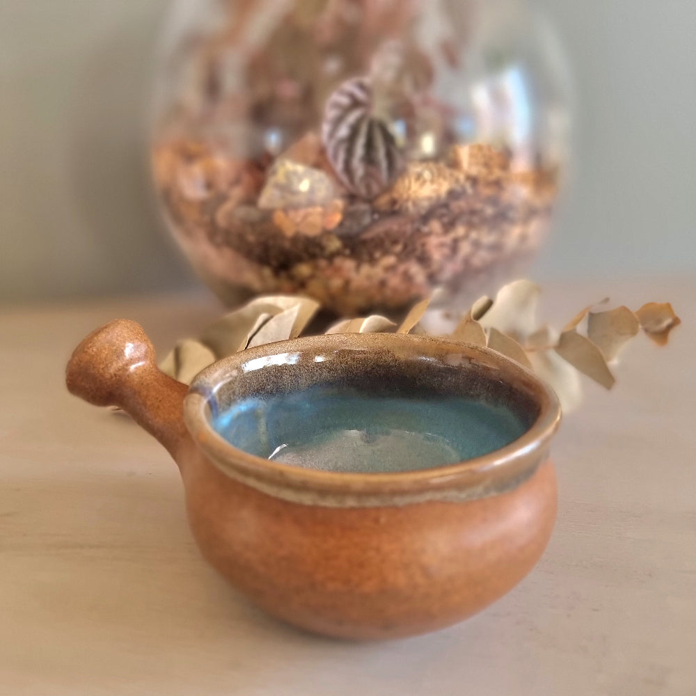 Handmade ceramic bowl with terracotta exterior and blue glaze interior