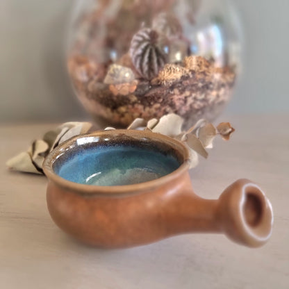 Handmade ceramic bowl with terracotta exterior and blue glaze interior