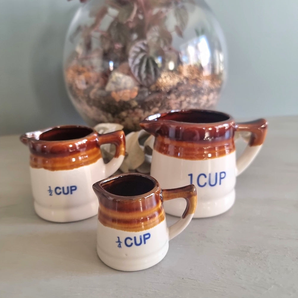 Vintage ceramic measuring jug set with brown drip glaze, three jugs