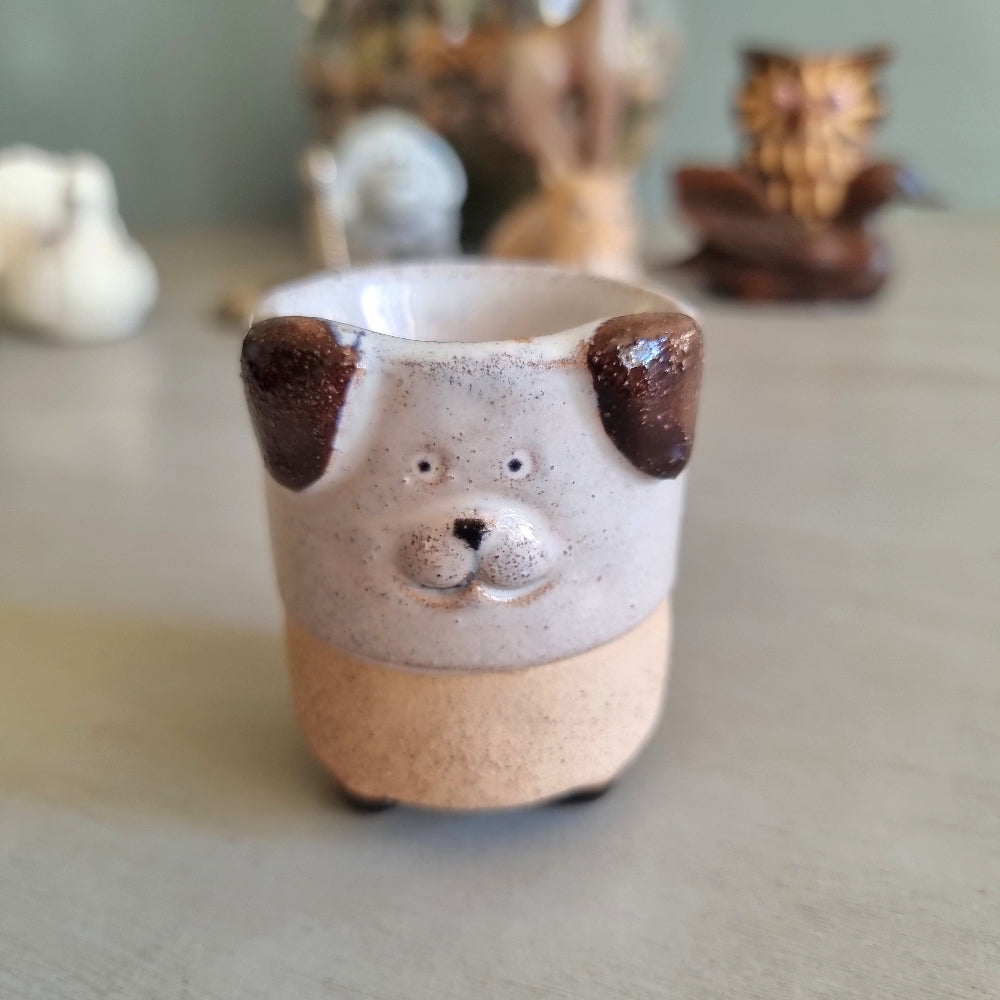 Handmade stoneware egg cup shaped like a dog face with speckled glaze