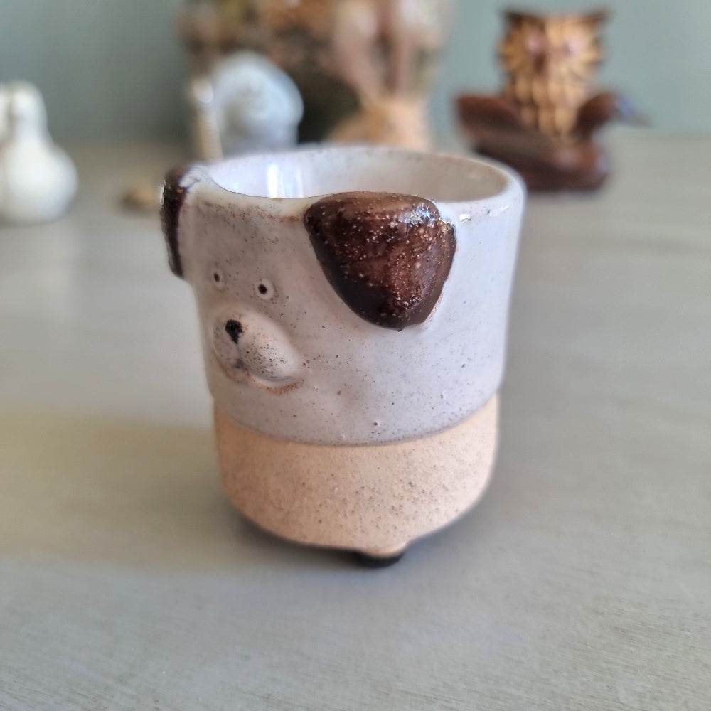 Handmade stoneware egg cup shaped like a dog face with speckled glaze