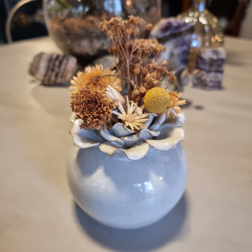 Sculptural ceramic bud vase with rose-shaped petal rim in cream glaze and speckled blue-grey body