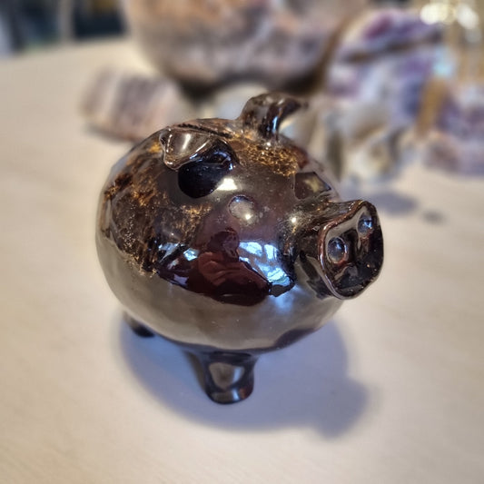 Vintage ceramic piggy money box in mottled brown glaze with speckled highlights, standing on four legs with a coin slot