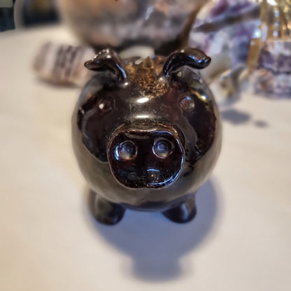 Vintage ceramic piggy money box in mottled brown glaze with speckled highlights, standing on four legs with a coin slot