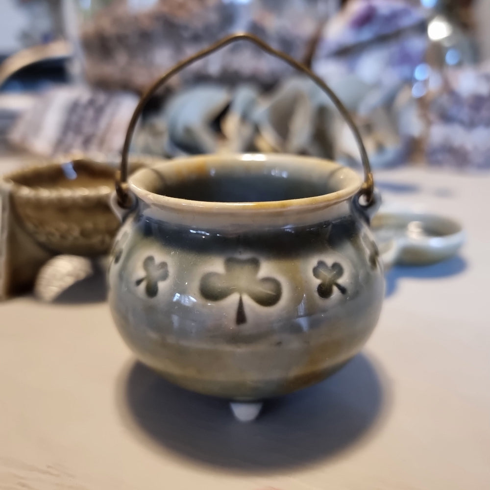 Trio of vintage Wade shamrock dishes in grey-blue glaze with honey brown highlights, including a footed dish, a pierced pot with wire handle, and a clover-shaped dish