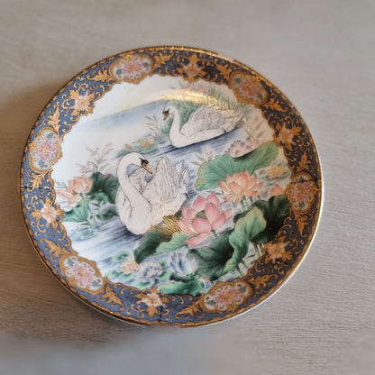 Decorative Japanese porcelain plate with swans and a lotus pond design
