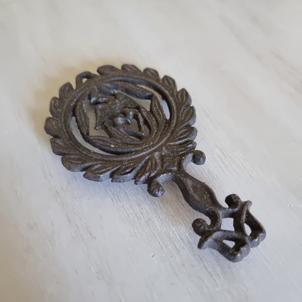 Wilton cast iron trivet with a lovebird and heart wreath design