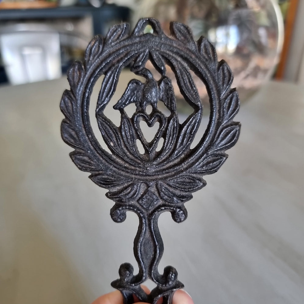 Wilton cast iron trivet with a lovebird and heart wreath design