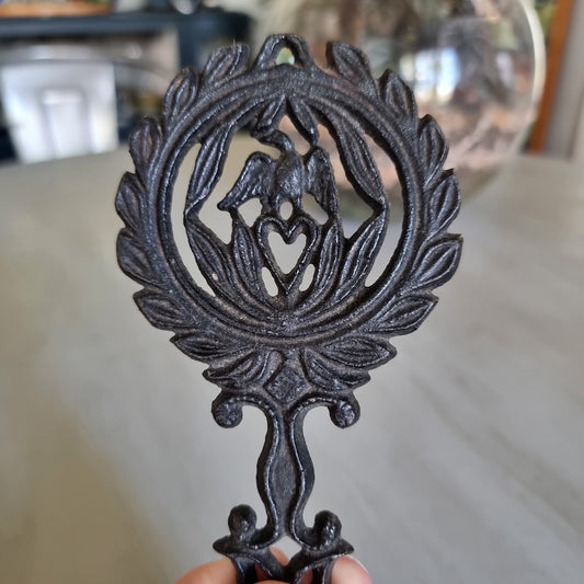 Wilton cast iron trivet with a lovebird and heart wreath design