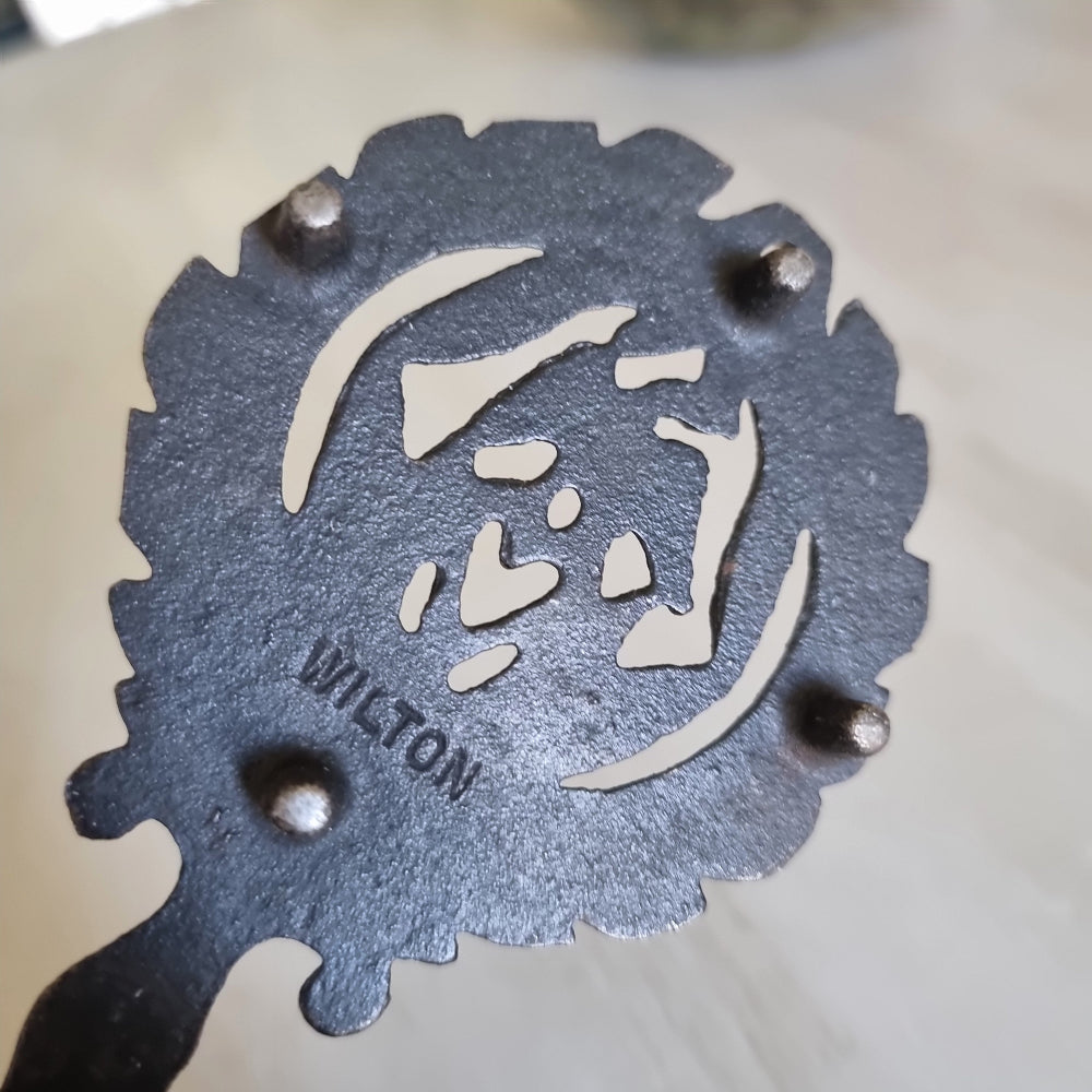 Wilton cast iron trivet with a lovebird and heart wreath design