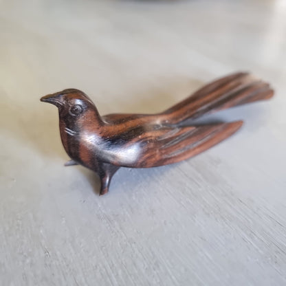 Carved wooden bird ornament with detailed feather carving