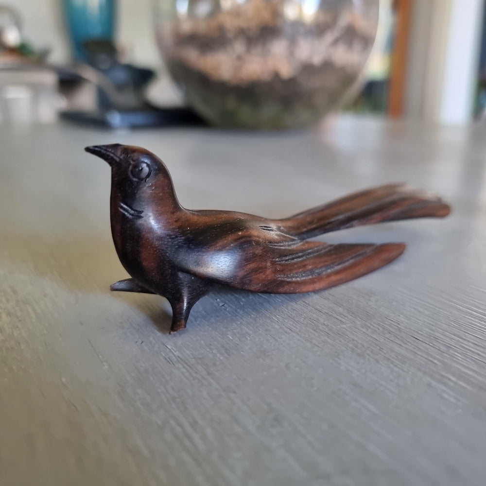 Carved wooden bird ornament with detailed feather carving