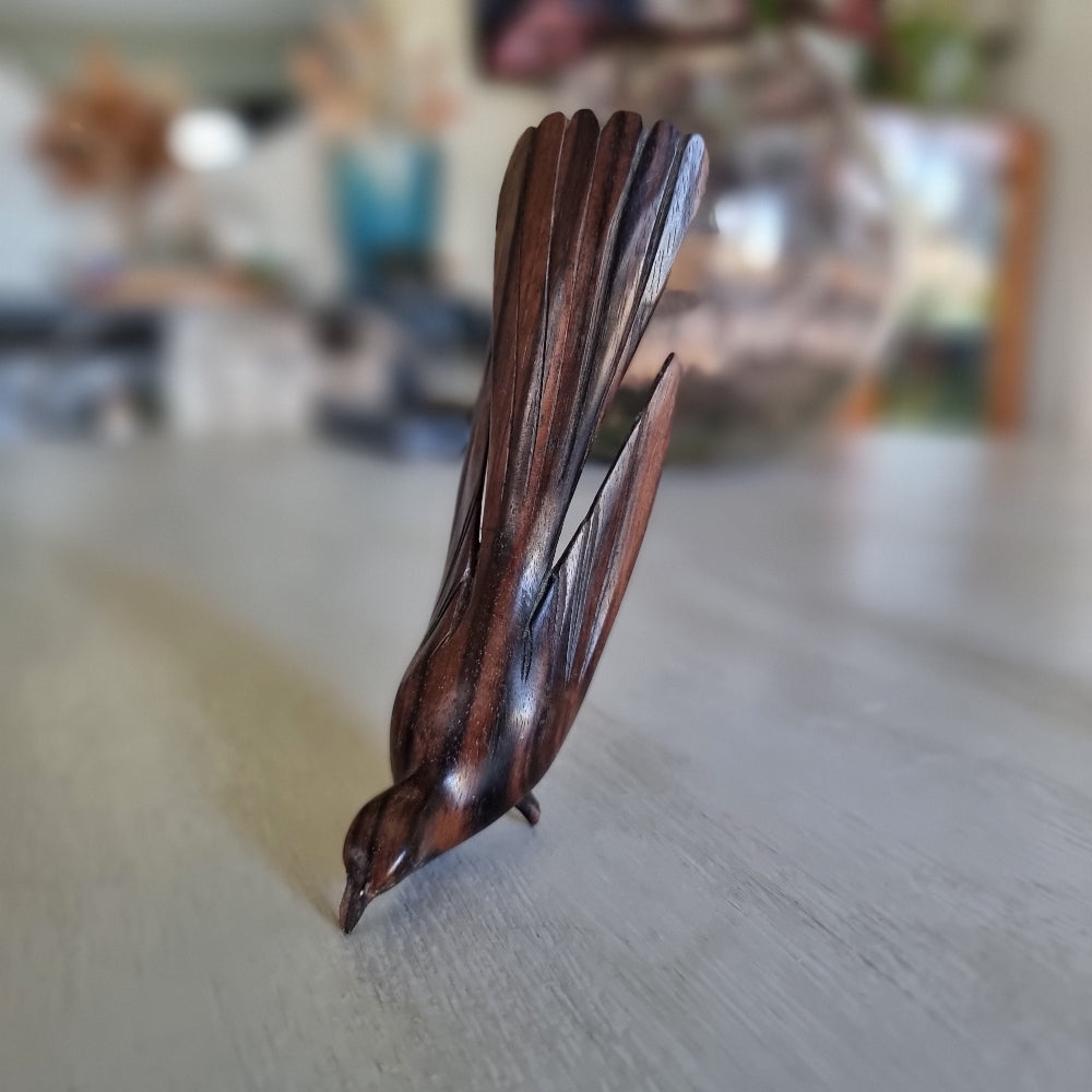 Carved wooden bird ornament with detailed feather carving