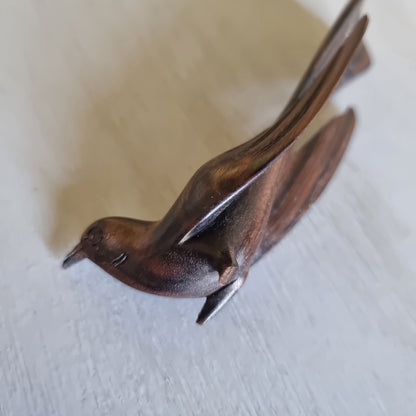 Carved wooden bird ornament with detailed feather carving