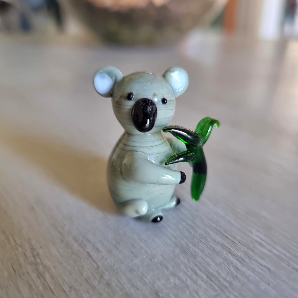 Hand blown glass koala magnet holding a eucalyptus leaf