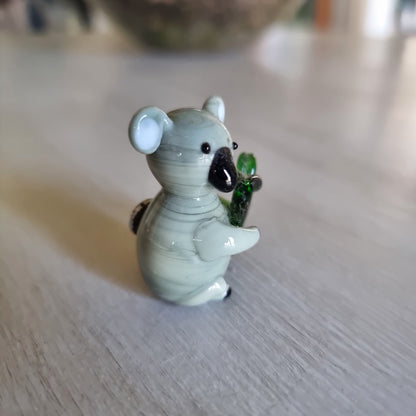 Hand blown glass koala magnet holding a eucalyptus leaf