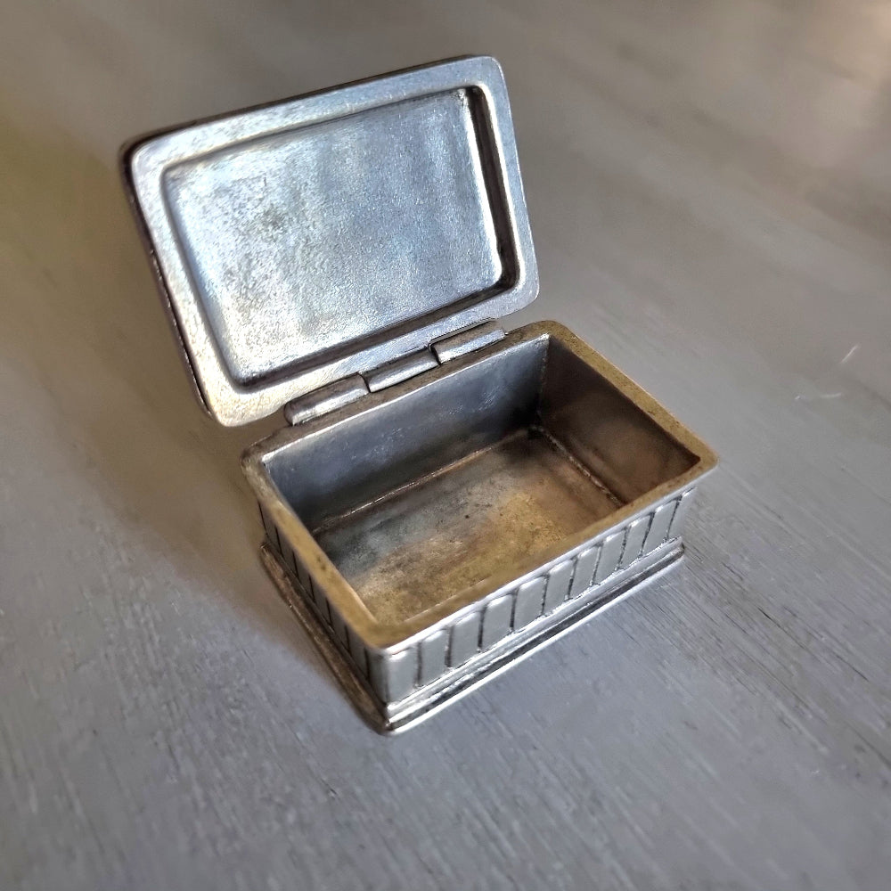 Small metal trinket box with a raised rose lid design