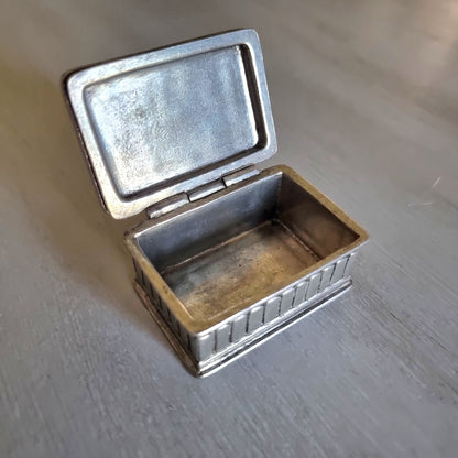 Small metal trinket box with a raised rose lid design